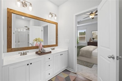 Bathroom featuring double vanity, a ceiling fan, a