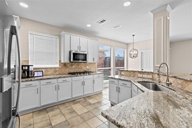 Kitchen with tasteful backsplash, pendant lighting