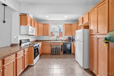 Kitchen with white appliances, sink, light tile pa