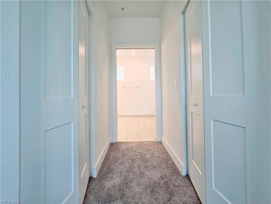 Corridor featuring carpet floors and baseboards