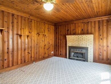 Living room with gas log fireplace. knotty pine walls and ceiling.