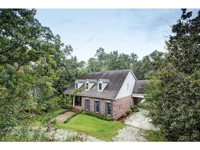 Photo. Brick home nestled in the woods with circul