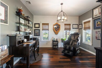 Home office with healthy amount of natural light, wood finished floors, and a chandelier