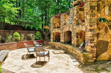 View of patio / terrace featuring an outdoor stone fireplace