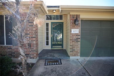 View of exterior entry with brick siding and an attached garage