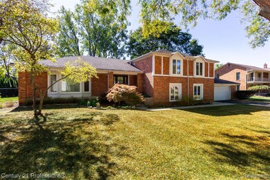 View of front of home with brick siding, a front lawn, and a garage