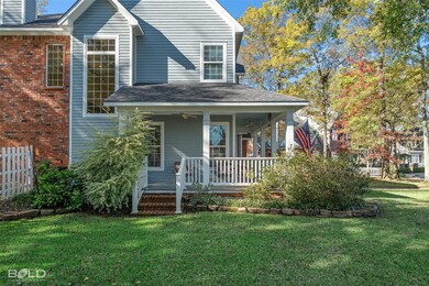 View of front of property with a ceiling fan, a porch, roof with shingles, and brick siding