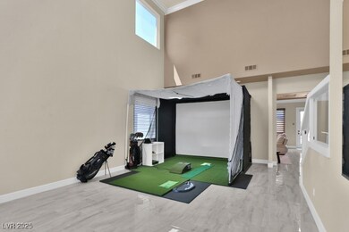Recreation room featuring a high ceiling and baseb