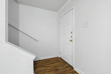 Entryway featuring dark wood-style flooring and a textured ceiling