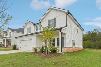 View of front of home with board and batten siding, a front lawn, and brick siding