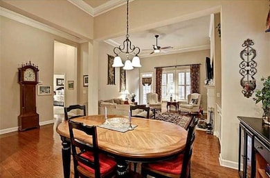 Dining area featuring crown molding, dark wood-style floors, a ceiling fan, and a chandelier