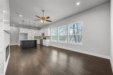 Unfurnished living room featuring ceiling fan, sink, and dark hardwood / wood-style flooring