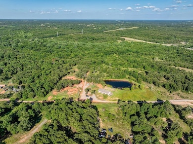 Aerial view of property's location with a heavily wooded area