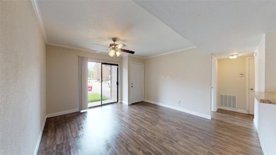 Spare room with visible vents, ceiling fan, crown