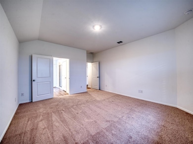 Unfurnished bedroom with light colored carpet, ba