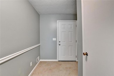 Doorway to outside featuring light carpet and base