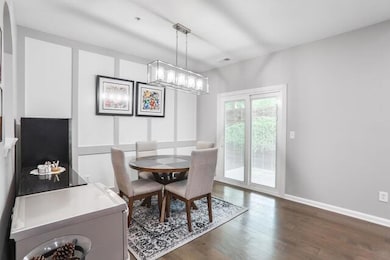 Dining room featuring wood finished floors, a chandelier, and baseboards