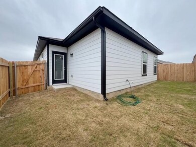 View of side of property featuring a lawn and a f