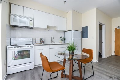 Kitchen with tasteful backsplash, white cabinets,