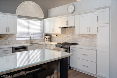 Kitchen with a sink, stainless steel gas range ove