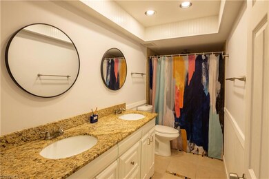 Bathroom featuring double vanity, tile patterned floors, recessed lighting, and a shower with shower curtain