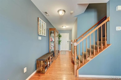 Foyer entrance with light wood finished floors and stairway