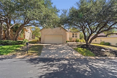 View of front of home featuring driveway, stone siding, and brick siding
