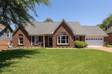 View of front of home featuring brick siding, a shingled roof, an attached garage, and driveway