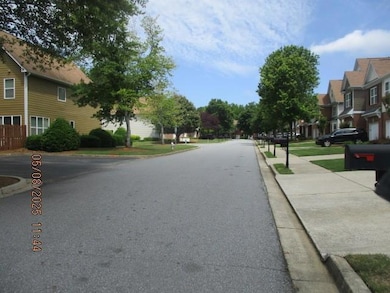 View of asphalt road featuring a residential view, curbs, and sidewalks