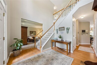 Foyer entrance featuring stairs, wood finished floors, and a towering ceiling