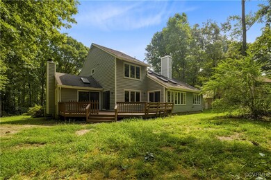 Rear view of house with a deck and a yard