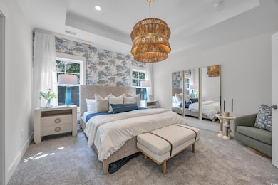 Bedroom with a tray ceiling, carpet flooring, and recessed lighting