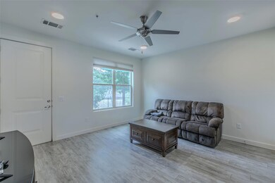 Living room featuring ceiling fan, light wood-sty