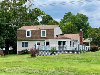 View of front of home with a deck and a front lawn