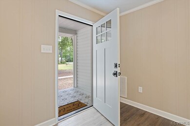 Doorway featuring ornamental molding and hardwood