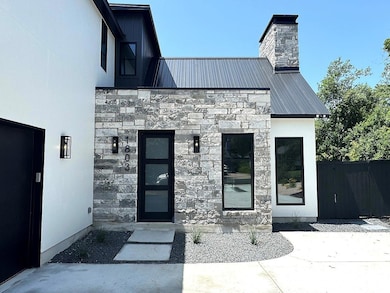 Property entrance featuring stone siding, a metal