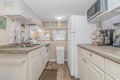 Kitchen featuring white cabinets, sink, light hard