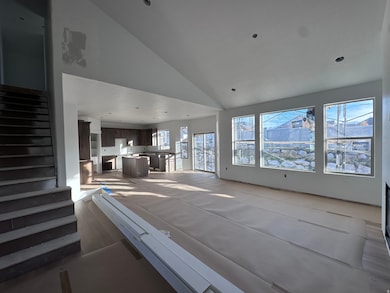 Living room featuring high vaulted ceiling and stairs