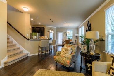 Living area with dark wood-type flooring, stairwa