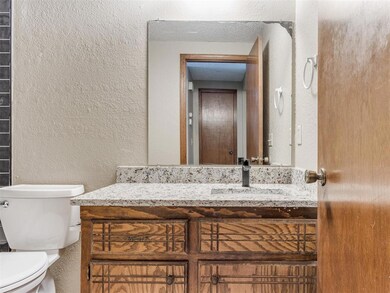 Bathroom with toilet, a textured wall, a textured 