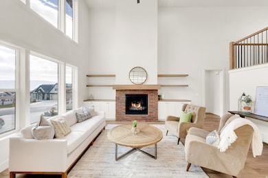 Living room featuring a towering ceiling, a fireplace, and wood finished floors