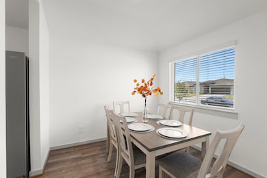 The breakfast nook boasts laminate flooring, a large window that fills the space with natural light, and recessed lighting for a cozy yet modern dining experience.