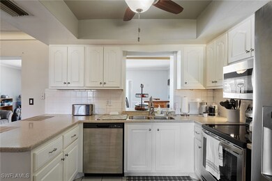 Kitchen with visible vents, ceiling fan, a peninsu