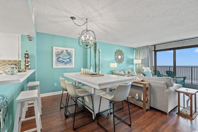 Dining area featuring expansive windows, a textured ceiling, a notable chandelier, and dark hardwood / wood-style flooring