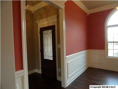 Dining room has 10 foot ceilings, half arch window, hardwood floors, chair rail with shadow box trim. crown molding. Picture from similar home.