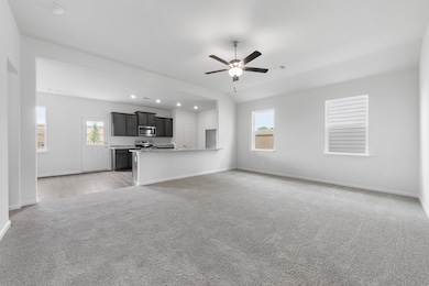Unfurnished living room with light carpet, a ceiling fan, and recessed lighting