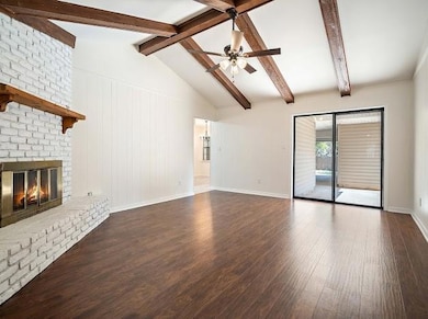 Unfurnished living room with a brick fireplace, lo