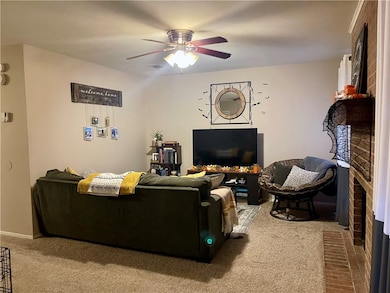 Living room with a fireplace, carpet floors, and c