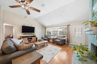 Bright, airy living room with vaulted ceilings and gas-log fireplace