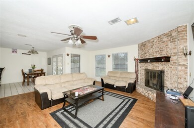 Living area with a brick fireplace, light wood-sty